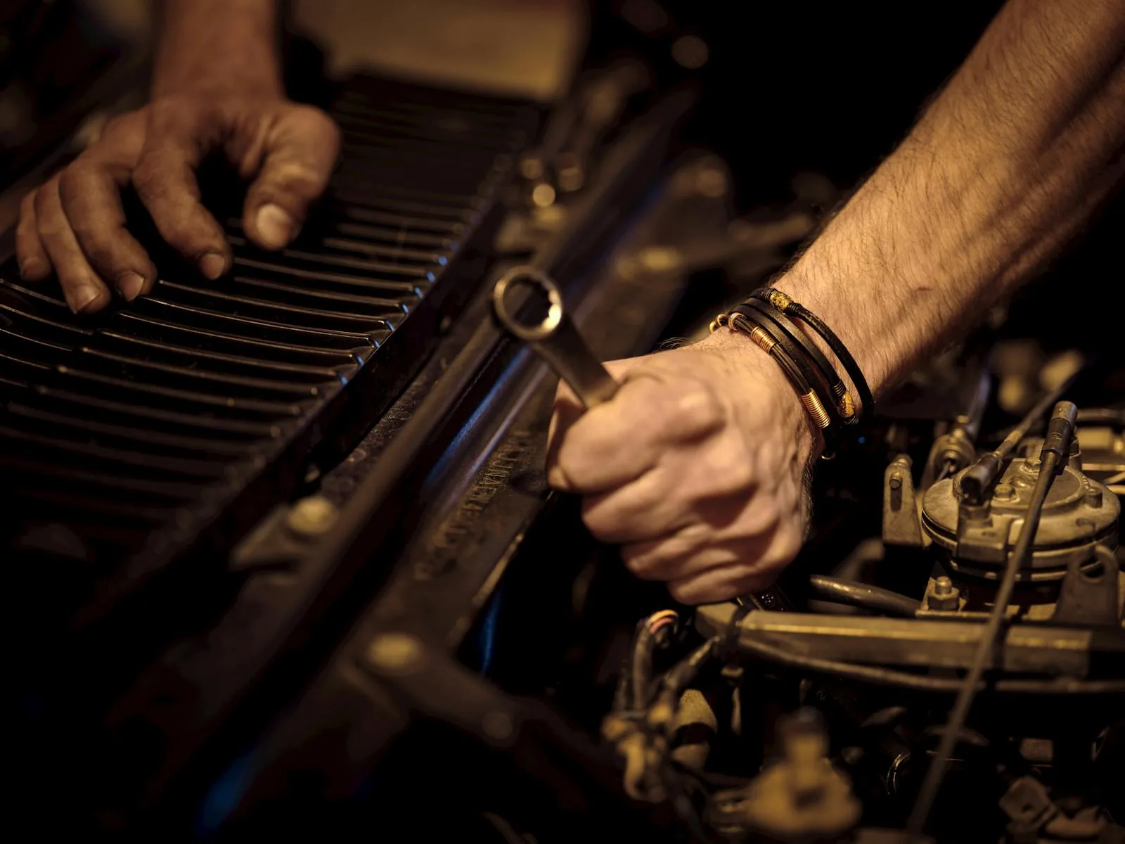 Mains de mécanicien sur un moteur, gros plan sans visage